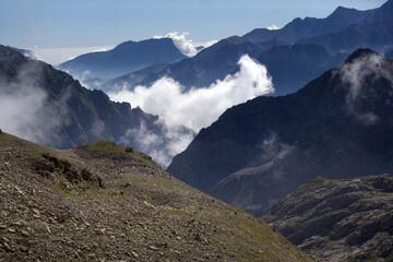 Mountain landscape with glaciers and clouds. View from the Koshtan mountain pass (3513 meters above sea level). Caucasus, Russia.