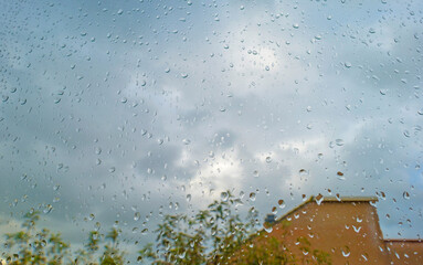 Dark and grey rain clouds over a windy rainy city and raindrops on a window pane in autumn, Almere, Flevoland, The Netherlands, October 7, 2020