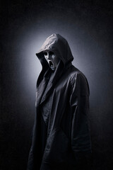 Scary figure with mask in hooded cloak in the dark - obrazy, fototapety, plakaty