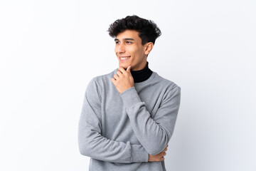 Young Argentinian man over isolated white background looking to the side