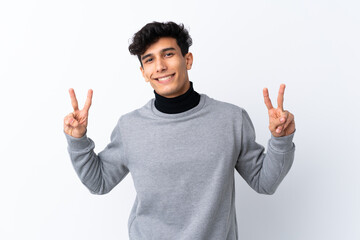 Young Argentinian man over isolated white background showing victory sign with both hands