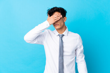 Young Argentinian businessman over isolated blue background covering eyes by hands