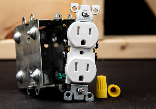 a standard American 15 amp duplex outlet and a metal outlet box in a construction environment