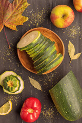 View from the top angle on zucchini, apples, tomato, lemon, bay leaf and one maple leaf