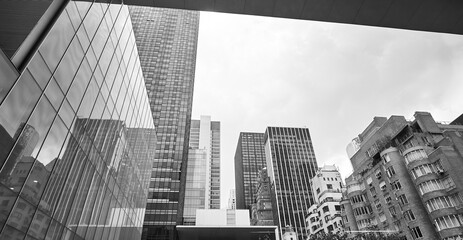 Black and white picture of New York City diverse architecture on a cloudy day, USA.