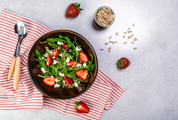 Diet menu. Healthy salad of fresh strawberries, arugula, ricotta and seeds on a bowl. Vegan food. Flat lay. Banner. Top view