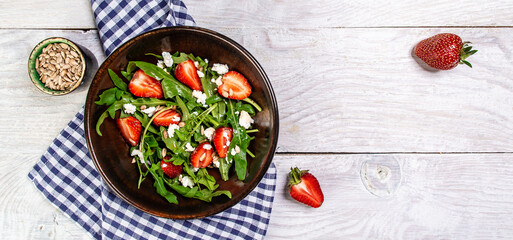 Diet menu. Healthy salad of fresh strawberries, arugula, ricotta and seeds on a bowl. Vegan food. Flat lay. Banner. Top view
