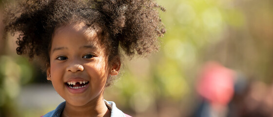 portrait of attractive african little sweet girl outdoors at park