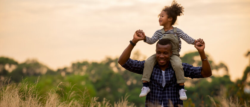 Enjoy togeter African Father with daughter on back at park