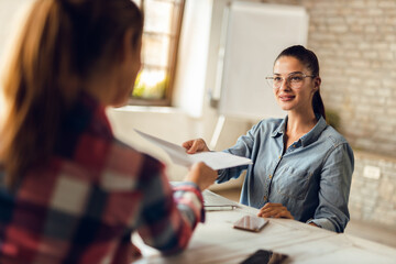 Smiling young insurance agent talking to a customer in the office