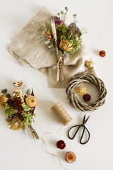 Dried flowers and herbs bouquets for making decoration flat lay on white background. Framing dried plants. Top view. Hobby handmade with flowers.