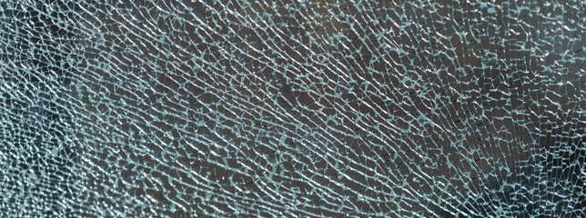 The geometry of the cracking glass. Glass breaking symmetry. The glass surface. White and gray colors. Suitable as natural background. Free space for message