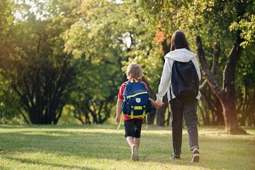 Fototapeta premium School Children return from school in a good mood. Brother and sister are walking along the park. 