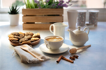 Cup of coffee with milk and cookies in relaxed atmosphere