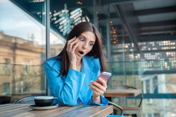 funny shocked woman looking at phone with open mouth