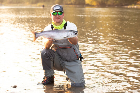 fisherman with salmon on river 