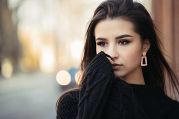 Close up lifestyle portrait of young indian woman is cold standing on the street cloudy weather,...