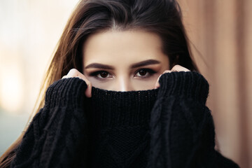 Close up lifestyle portrait of young indian woman is cold standing on the street cloudy weather,...
