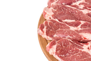 Raw and fresh sliced ​​pork meat laid out on a wooden round board, isolated on white background.