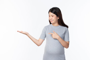 Young beautiful pregnant woman stand and touching belly showing empty copy space on the open hand palm for text isolated on white background. Pregnancy, motherhood, people and expectation concept.