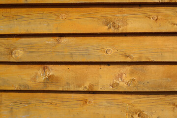 Decorative slice of orange plank patterns on wood wall texture for background.