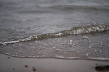 Fototapeta na wymiar White foamy waves of dark water.