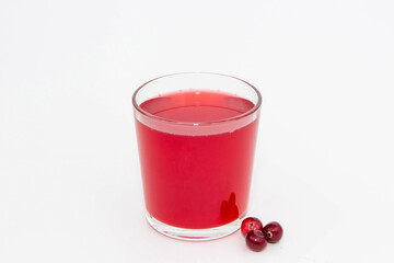 Red fruit drink from cranberries in a glass glass on a white background.