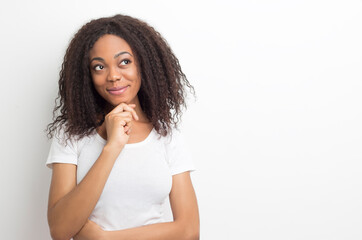 Smiling African thinking girl on a white background. Black young pensive woman. Idea concept.