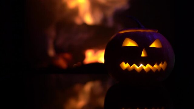 Creepy halloween pumpkins near a fireplace. Fire on the background.