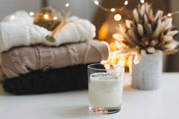 Christmas background. Candle, knitted sweater, christmas decorations and bokeh lights background....