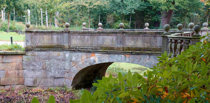 Alte Steinbrücke von 1704. Die Steinbalustrade ist wunderschön gemacht. Das Wasser darunter ist vollständig mit Wasserlinsen bedeckt. Ort: Kloster Frenswegen in Nordhorn, Deutschland