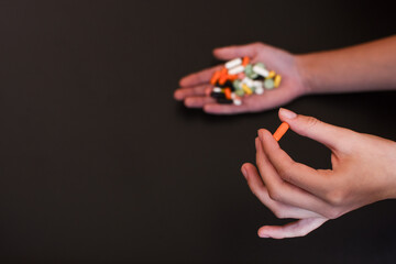 Colorful pills and medicines in the handson black background.. Place for an inscription. 