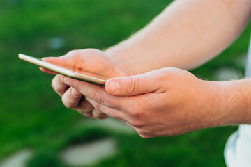 male hands holds digital pc t mock up for your text message or informational content, on the background of green nature