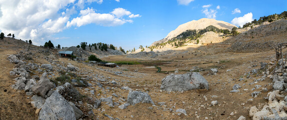 Alpine farm on Chukur Yayli. A huge valley in the mountains is surrounded by rocks. Panoramas of the Lycian trail in Turkey.