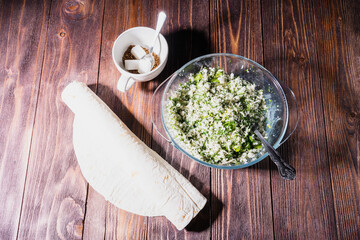 cannelloni, cottage cheese with greens in pita bread on a plate