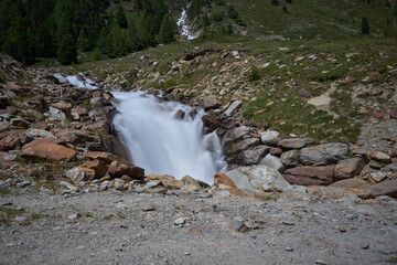 kleiner Wasserfall in Loch Bachlauf in den Bergen als Langzeitbelichtung
