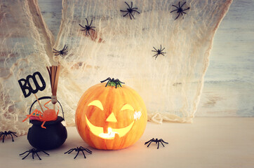 holidays halloween concept image. Pumpkin, spiders over wooden table