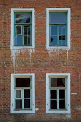 Fototapeta na wymiar Vertical detail shot of vintage old brick wall with broken windows for background. Red and white contrast texture