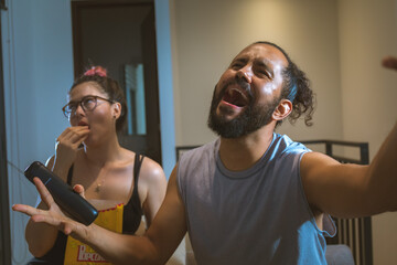 Pareja de novios casados comiendo palomitas viendo television pelicula en casa comodos