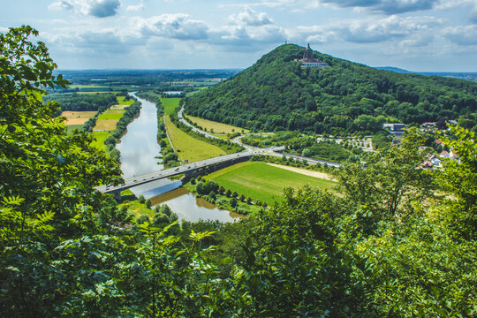 Emperor William Monument on top of Wittekindsberg and the Weser river on the left. Near the city of Porta Westfalica, North Rhine Westphalia, Germany. View from Portakanzel viewpoint.
