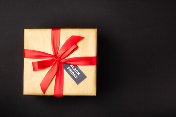 Top view of gift box with price tag with black friday on black background