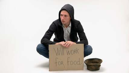 Poverty and unemployment concept. Poor man with cardboard sign ready to work for food. Isolated on white background.