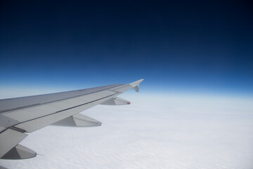 airplane wing against the background of clouds and sky