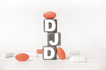 a group of white and red pills and cubes with the word DJD Degenerative joint disease on them, white background. Concept carehealth, treatment, therapy.