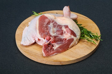 Raw duck leg served rosemary