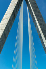 Fototapeta premium Detail of suspension bridge, support tower and tie rods or tension cables