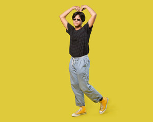 Fototapeta na wymiar young asian man give big love gesture with his arm. isolated on yellow background. with clipping path