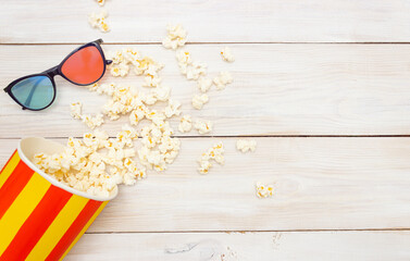 Concept movie preview of the film. Popcorn spills out of the box and 3D glasses. Light wooden...