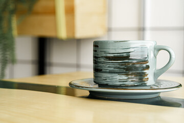 Stylish green ceramic cup of coffee on wooden table