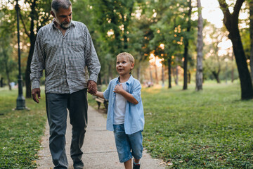 grandfather and grandson walking in park